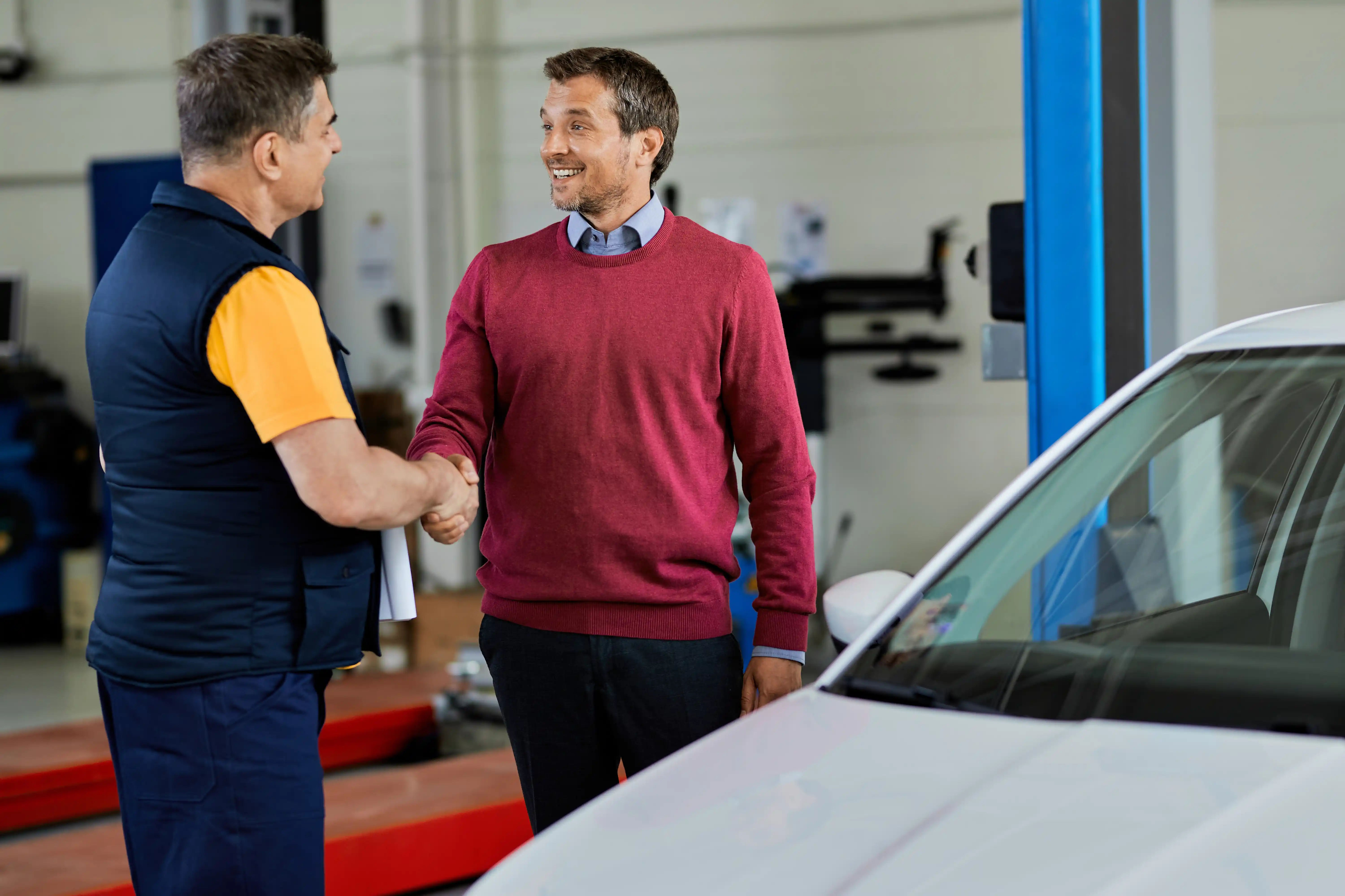 Garagiste professionnel accueillant un client dans son atelier